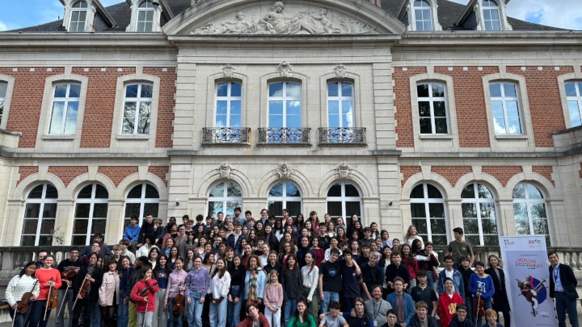 Photo-souvenir de l'ensemble des élèves membres de l'Orchestre des lycées français du monde, avec leurs mentors. Le groupe pose ici devant l'École européenne de Bruxelles, établissement proche du lycée français Jean-Monnet, qui a très aimablement mis à disposition des locaux pour les répétitions.